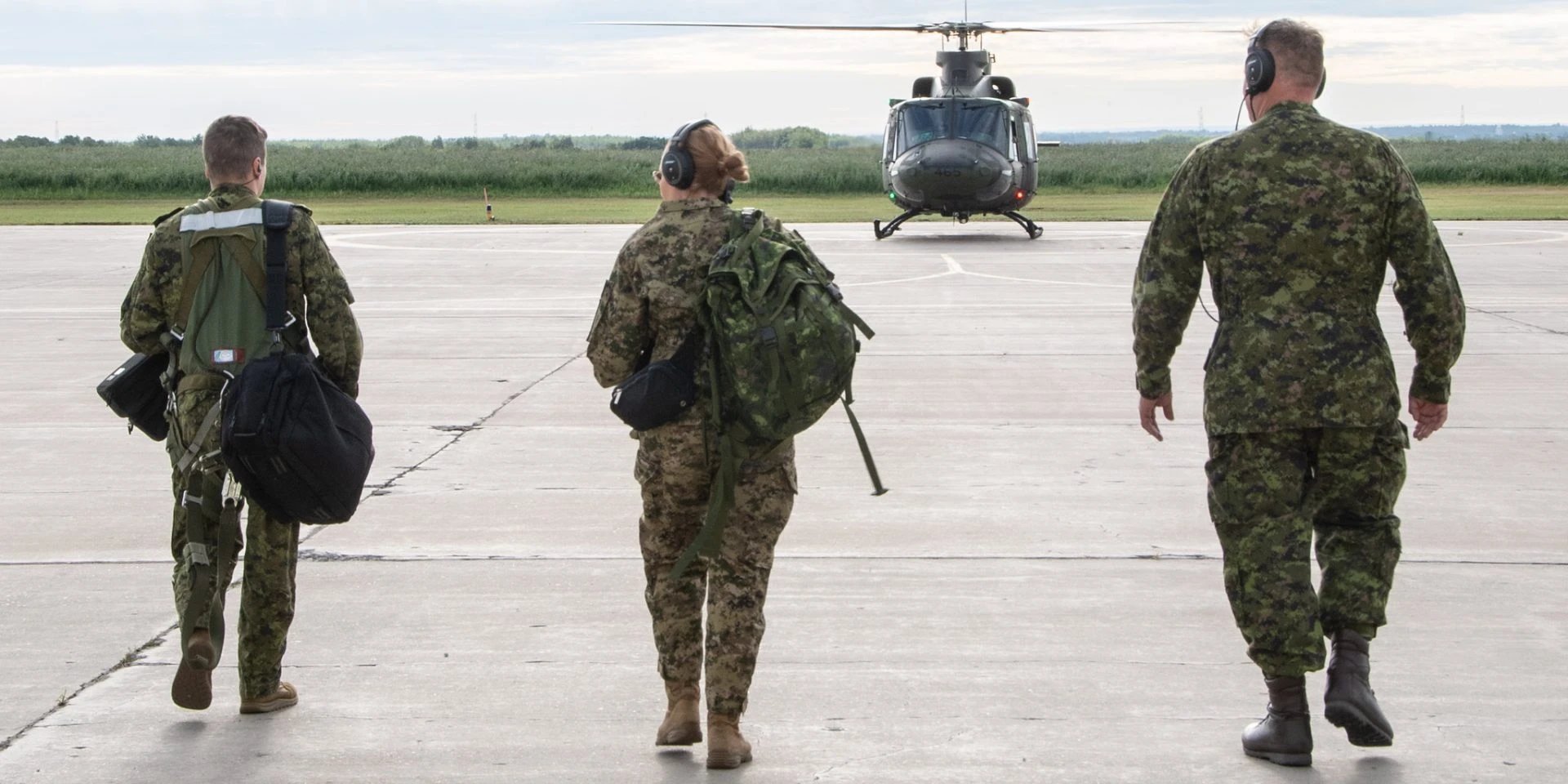 Aircrew walking toward a helicopter on a Canadian airfield